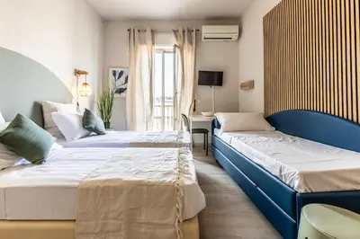 a hotel room with two beds and a tv at Dafne Rooms a relaxing piece of paradise in Rome