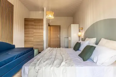 a bedroom with a large white bed and a blue couch at Dafne Rooms a relaxing piece of paradise in Rome