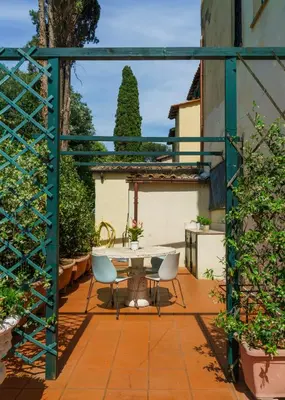 a patio with a table and chairs in a garden at Villa Mara Appia antica in Rome