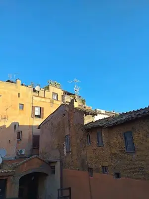 an old brick building with a blue sky in the background at Angolo dè Trastevere - Accogliente e silenzioso in Rome