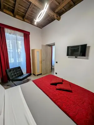 a bedroom with a bed with a red blanket on it at Domus Forus in Rome
