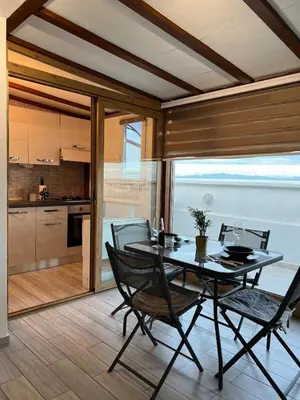a dining room with a table and chairs and a kitchen at Vivi in un attico tipico Romano con vista su Roma in Rome