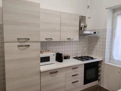 a kitchen with wooden cabinets and a microwave at San Pietro Green Home in Rome