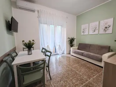 a living room with a couch and a table and chairs at San Pietro Green Home in Rome