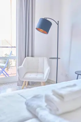 a white bedroom with a white chair and a lamp at B&B ErinaHouse in Rome