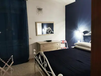 a bedroom with a bed with a blue wall at La Regina Tiberina in Rome