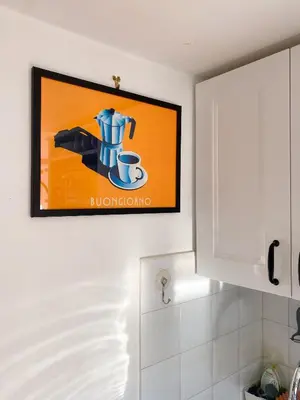 a television hanging on a wall in a kitchen at The Artful Flat in Rome