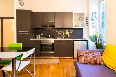 a kitchen with brown cabinets and a table and a couch at Maison Doria Vaticano in Rome
