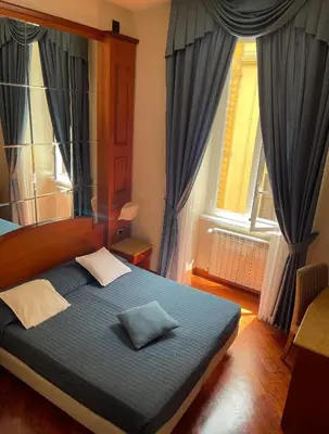 a bedroom with a large bed with blue curtains at 69 Manin Termini in Rome