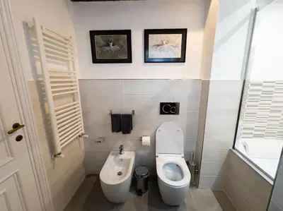 a white bathroom with a toilet and a bidet at Stelletta Apartment in Rome