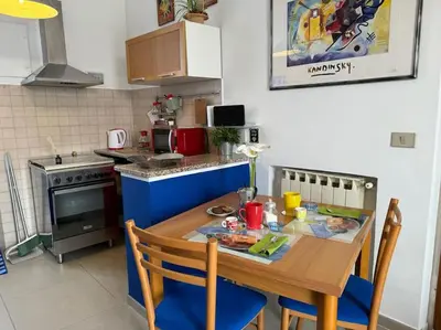 a kitchen with a wooden table with chairs and a stove at Blue Sky in Rome