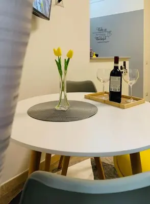a white table with a vase with a bottle of wine at Portami in Villa -Gianicolo in Rome