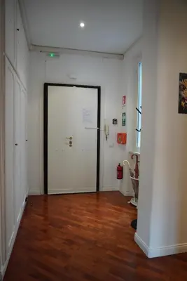 a hallway with a large white door and a wooden floor at Holidays Palumbo in Rome