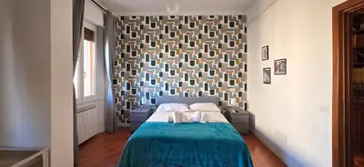 a bedroom with a bed with a blue bedspread and a wall at Holidays Palumbo in Rome