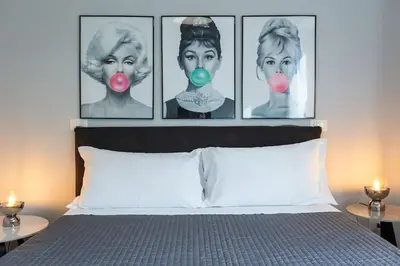 a bedroom with four pictures of a woman with pink noses at Dona's House in Rome