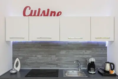 a kitchen with white cabinets and a sink at Dona's House in Rome