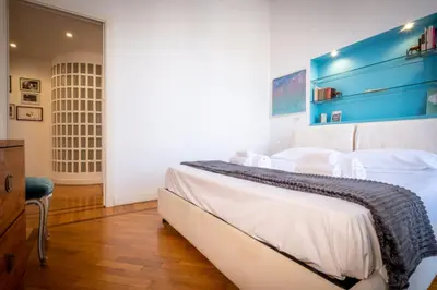 a bedroom with a bed with white sheets and a blue wall at Vatican Museum apartment by Varental in Rome