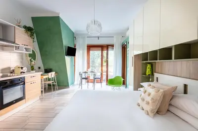 a bedroom with a large white bed and a kitchen at Vaticano 44 by Hili in Rome