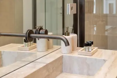 a bathroom sink with four soap dispensers on a counter at Skylife Minimalist Boutique Apartment in Rome