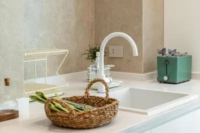 a sink with a basket and a faucet on a counter at Skylife Minimalist Boutique Apartment in Rome