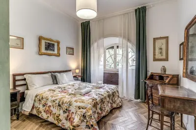 a bedroom with a bed and a desk and a window at Casa Belle Arti in Rome