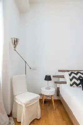 a bedroom with a bed and a chair and a lamp at Casa Girasole in Rome