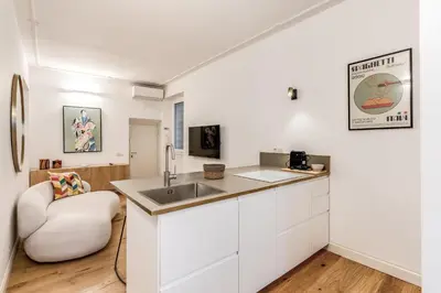 a kitchen with white cabinets and a sink and a chair at Silent 2 Bdrm heart of Trastevere in Rome