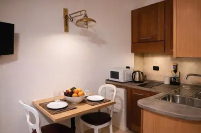 a kitchen with a table with a bowl of fruit on it at Piazza Navona Historic Escape in Rome