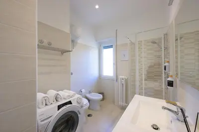 a bathroom with a washing machine and a toilet at Luxury Suite-Metro Malatesta in Rome