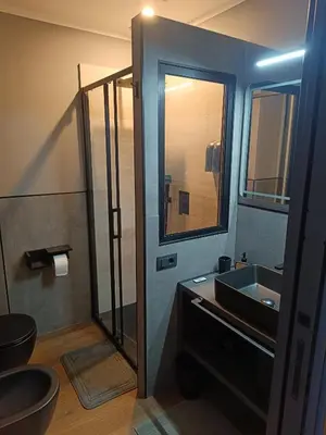 a bathroom with a sink and a glass shower at Trastevere Noir in Rome