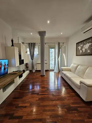 a living room with a white couch and a tv at A Casa di Luca in Rome