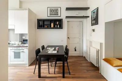 a kitchen and dining room with a black table and chairs at San Giovanni Living House in Rome