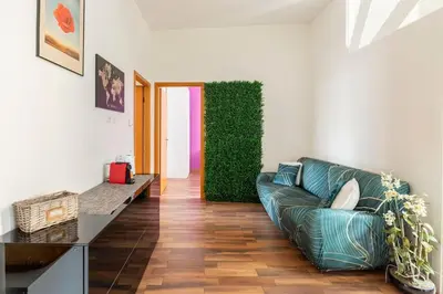 a living room with a couch and a green wall at San Giovanni Living House in Rome