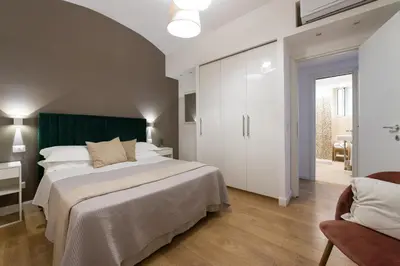 a bedroom with a large white bed and a chair at Maison Aurora in Rome