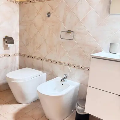 a bathroom with a white toilet and a sink at Angelico Home in Rome