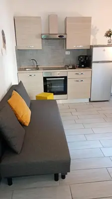 a living room with a couch in front of a kitchen at Ponte Milvio Loft in Rome