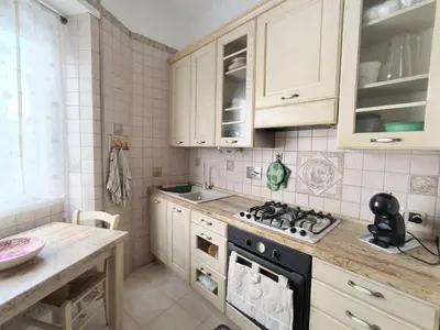 a kitchen with white cabinets and a stove top oven at Alloggio Turistico Giotta in Rome