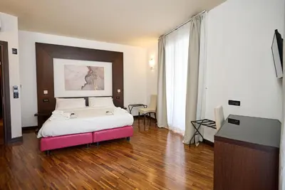 a bedroom with a large bed with a pink foot board at Gemini Rooms in Rome