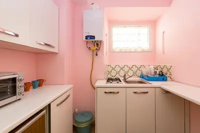 a pink kitchen with a sink and a microwave at Holiday Home Naiadis in Rome