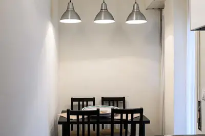 a dining room table with two chairs and two lights at Casa Tiburtina in Rome