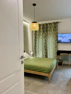 a bedroom with a green bed and a window at Alma Domus Feriae - Roma in Rome