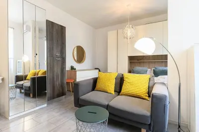 a living room with a gray couch and yellow pillows at Casa Vacanze Marrucini in Rome
