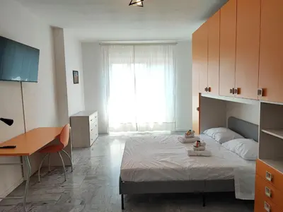 a bedroom with a bed and a desk and a window at Al Trilocale Romano Metro A in Rome