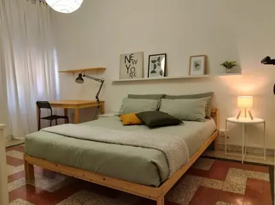 a bedroom with a bed with two pillows and a desk at A casa di Gi in Rome