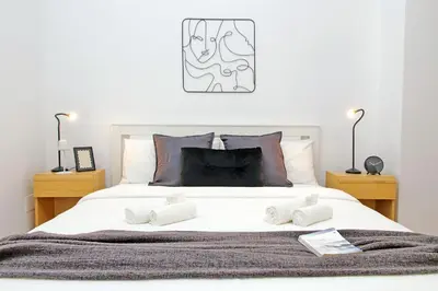a bedroom with a large white bed with two lamps at Carmens Flat by DomusDimore in Rome