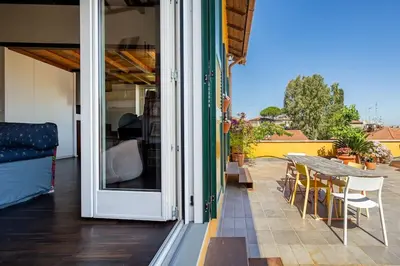 a sliding glass door to a patio with a table and chairs at Loft in Garbatella in Garbatella