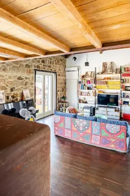 a living room with a couch and a stone wall at Loft in Garbatella in Garbatella