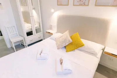 a bedroom with a white bed and a mirror at Atella Rome Apartment in Rome