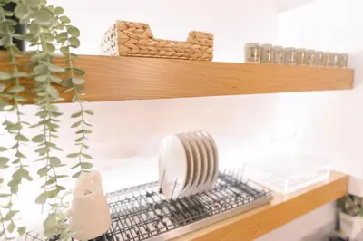 a kitchen shelf with a fan on a metal grate at Atella Rome Apartment in Rome