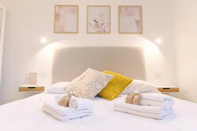 a bedroom with a white bed with towels on it at Atella Rome Apartment in Rome